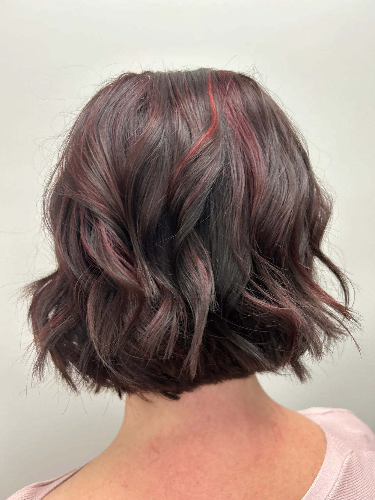 Deep brunette bob with vivid red ribbon highlights